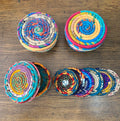 Set of colorful woven coasters on a wooden surface