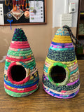Colorful fabric bird houses on a wooden surface with a blurred background