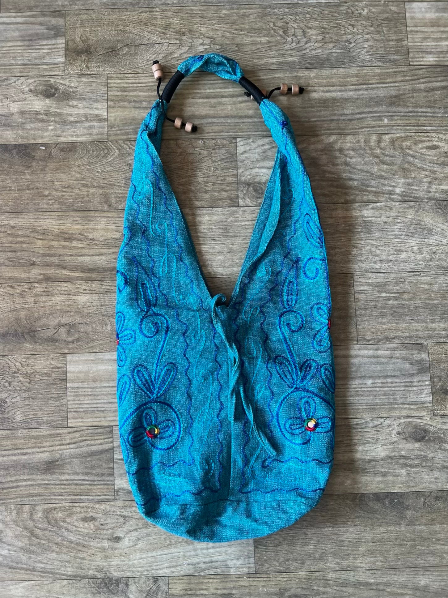 Handmade embroidered hobo bag with colorful floral threadwork and bohemian design
