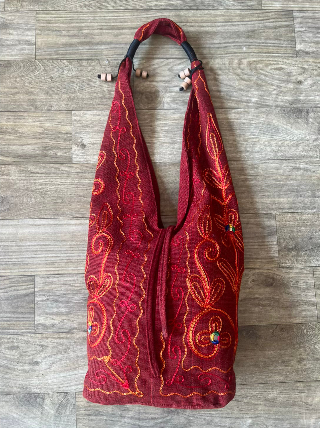 Handmade embroidered hobo bag with colorful floral threadwork and bohemian design Handmade embroidered hobo bag with colorful floral threadwork and bohemian design