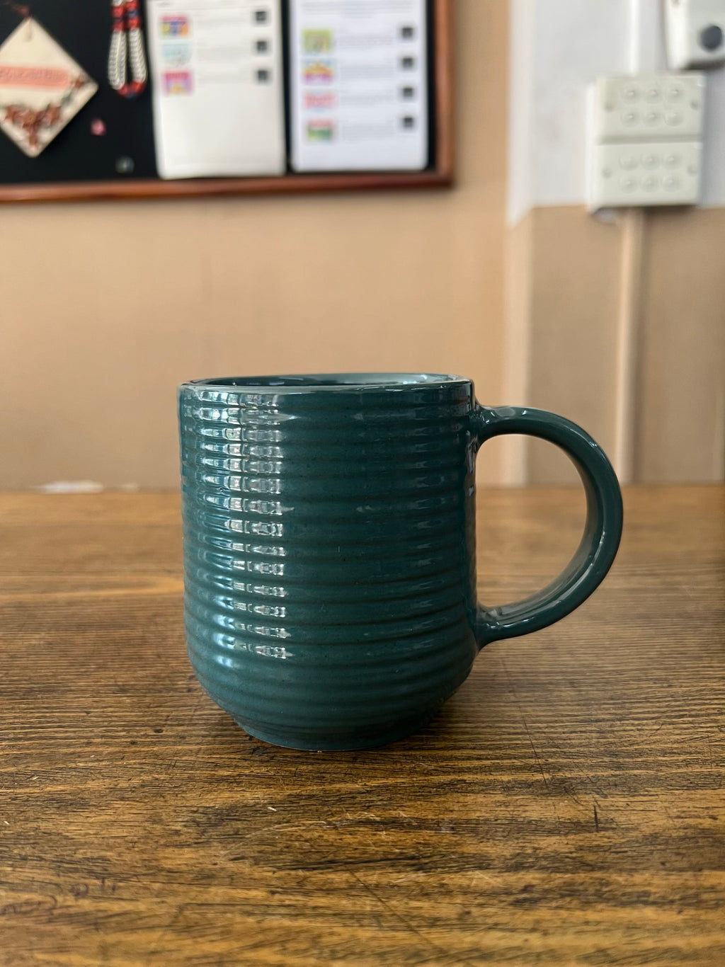 Green mug on a wooden surface with a blurred background