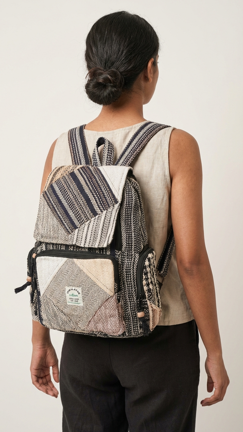 Person wearing a patterned hempcotton patchwork backpack on a plain background
